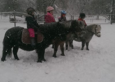 4 enfants sur leurs poneys en hiver