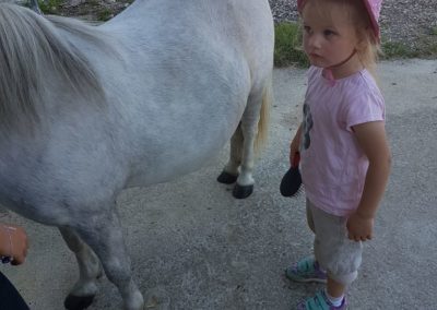 Une petite fille à côté de son poney